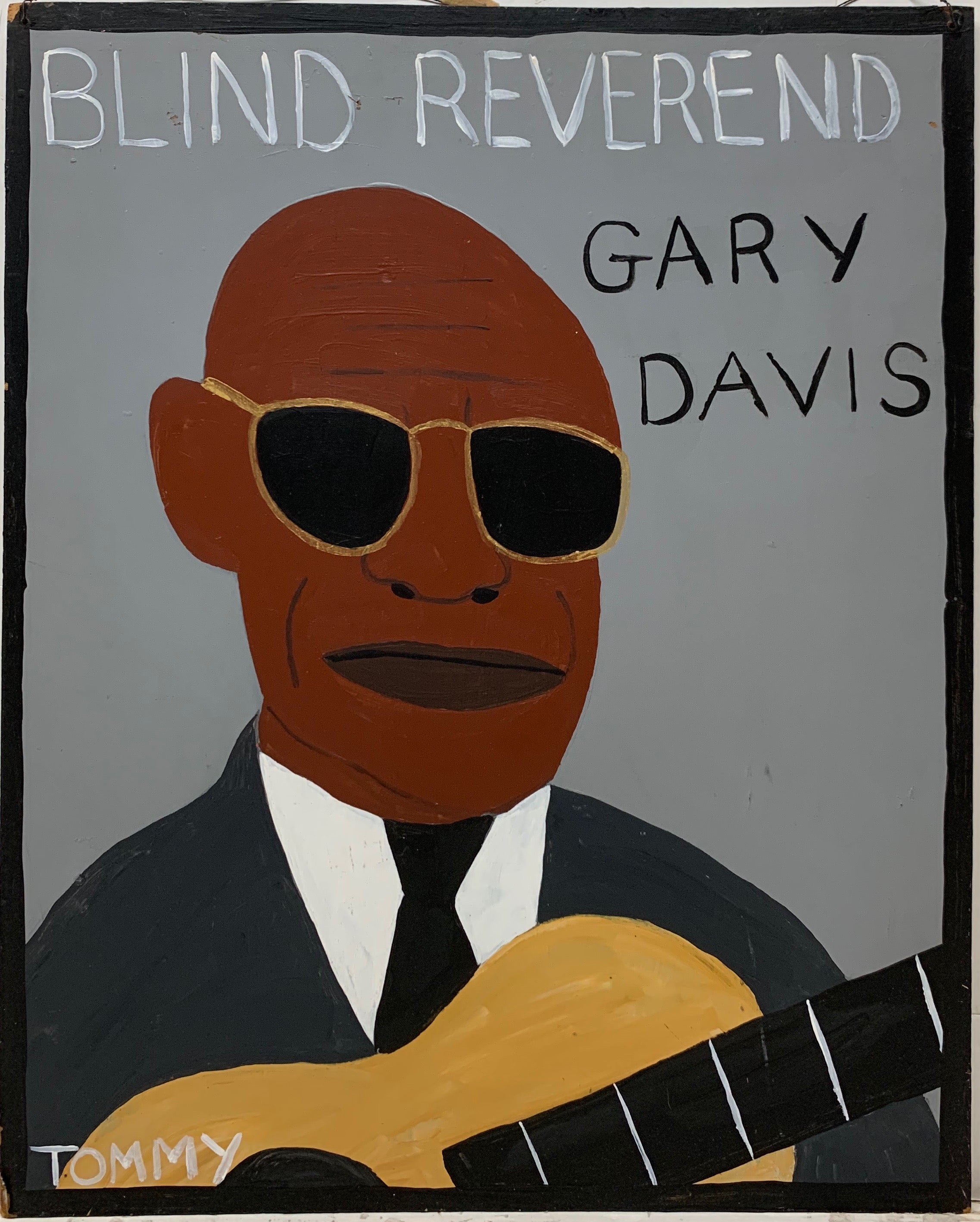 A Tommy Cheng portrait of Blind Reverend Gary Davis wearing a black tux, gold-rimmed sunglasses, and holding his brown wooden guitar.
