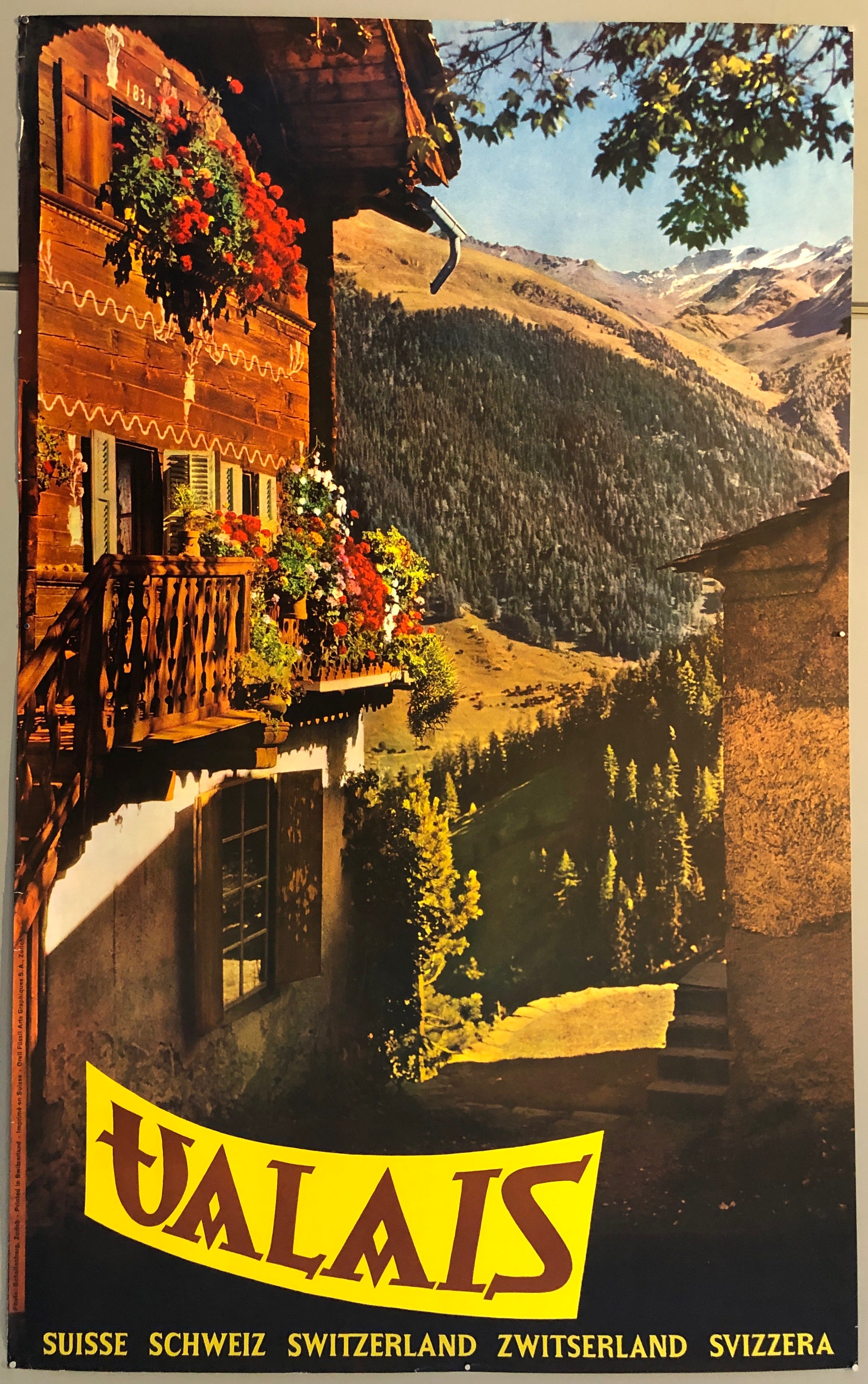 Poster showing a photograph of a cottage before a stream, a mountain range in the background