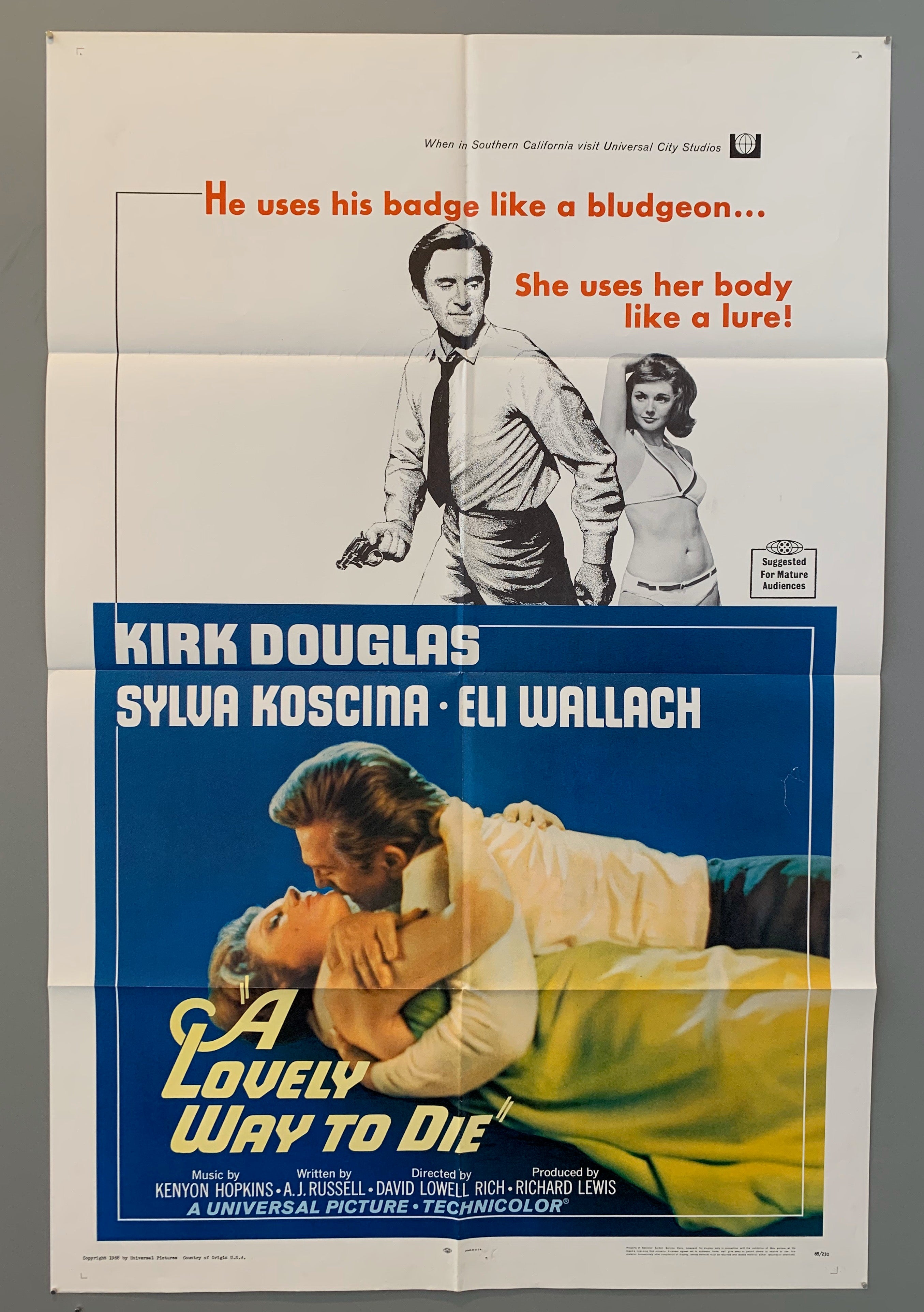 man with gun and woman in bikini at top. man and woman embracing lying down both dressed