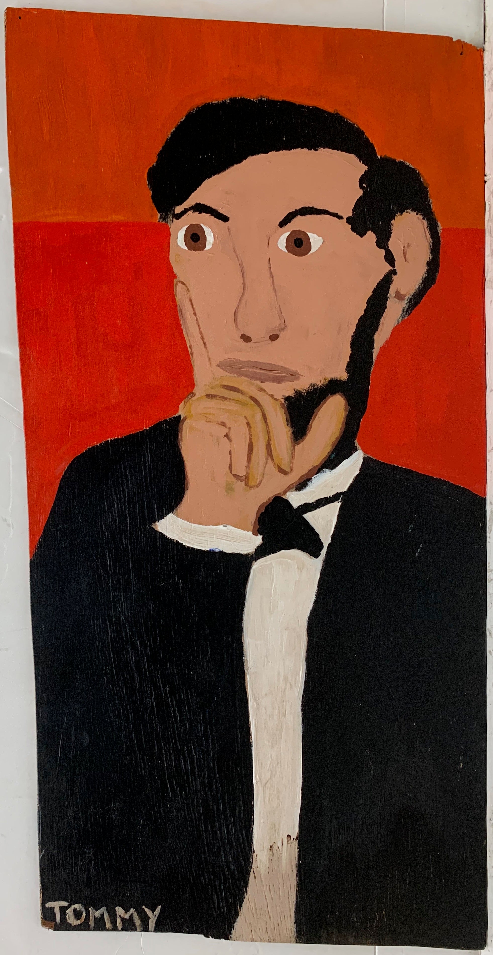 A Tommy Cheng portrait of Abraham Lincoln in a black suit against a red background.