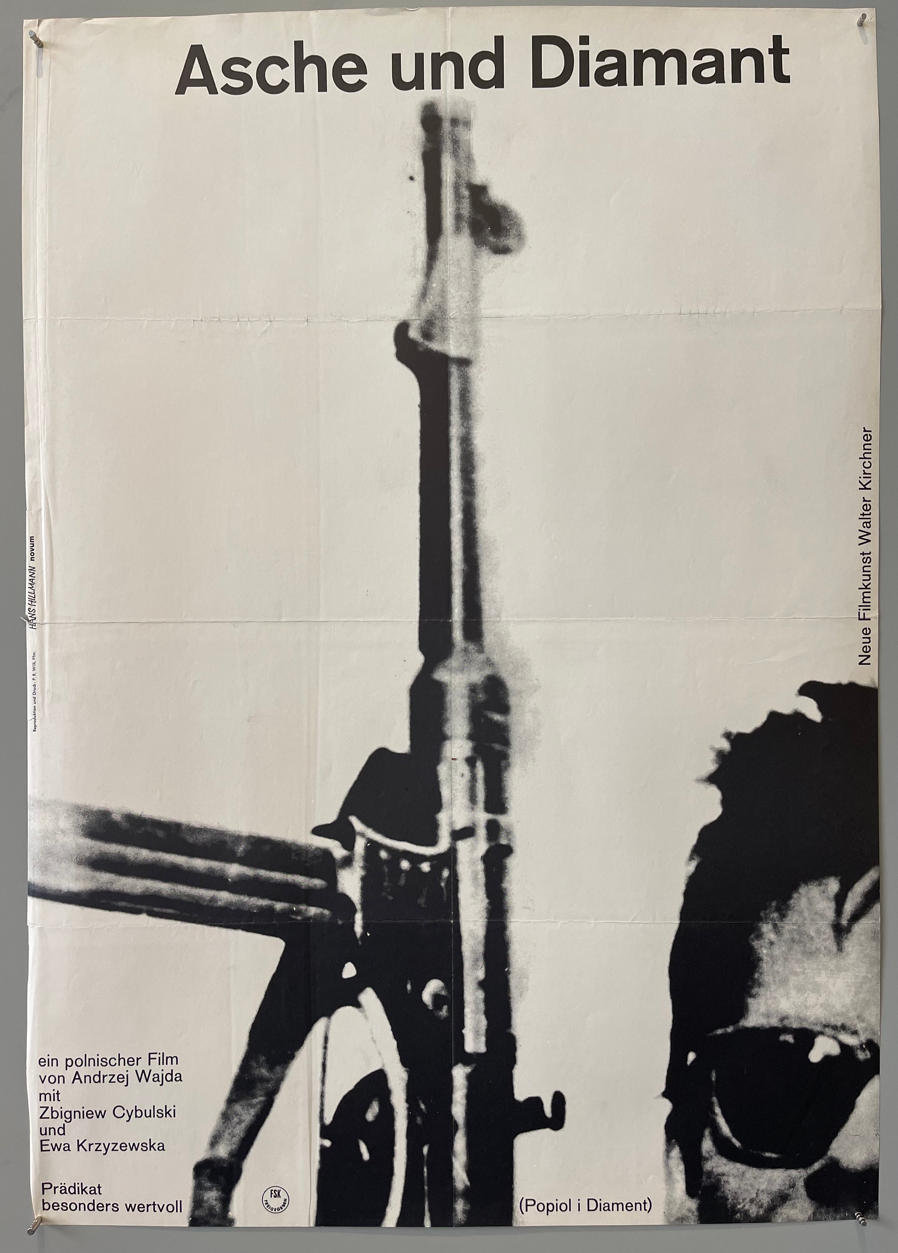 Half of a man's face in bottom right corner holding a rifle pointing straight up the middle of poster.