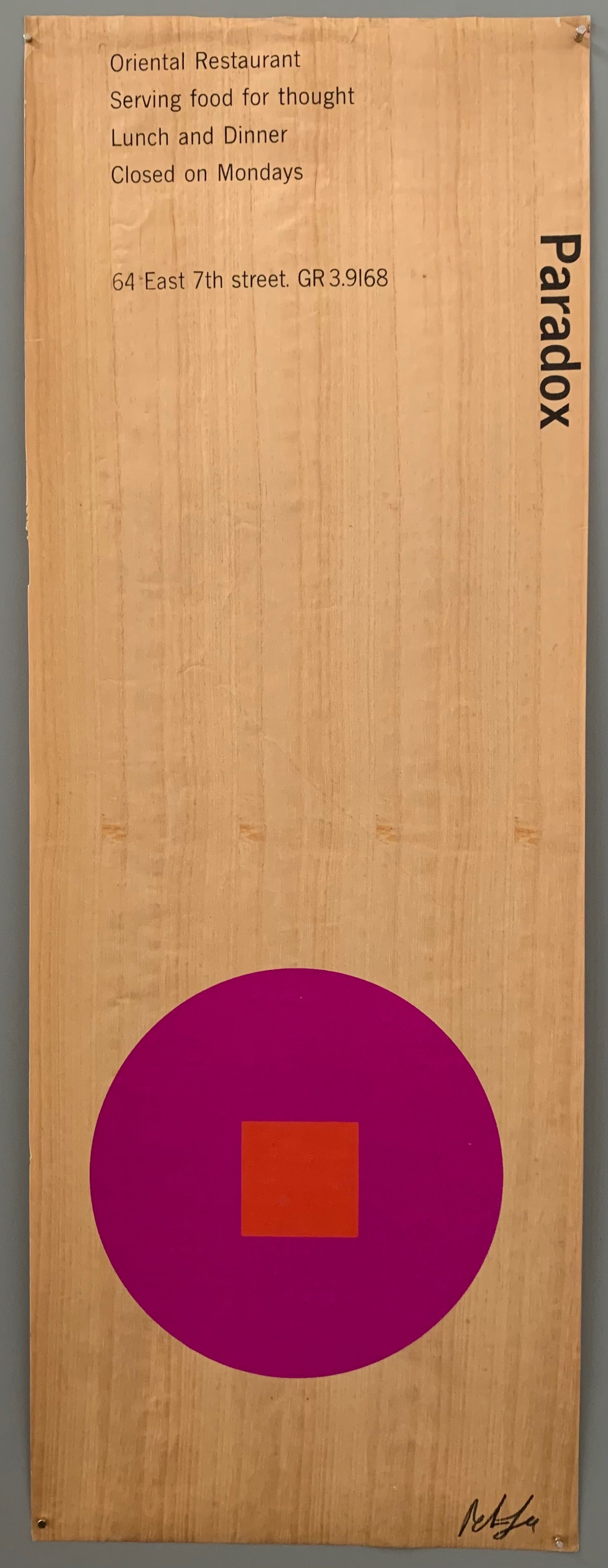 A purple circle with a red square on wood patterned paper.