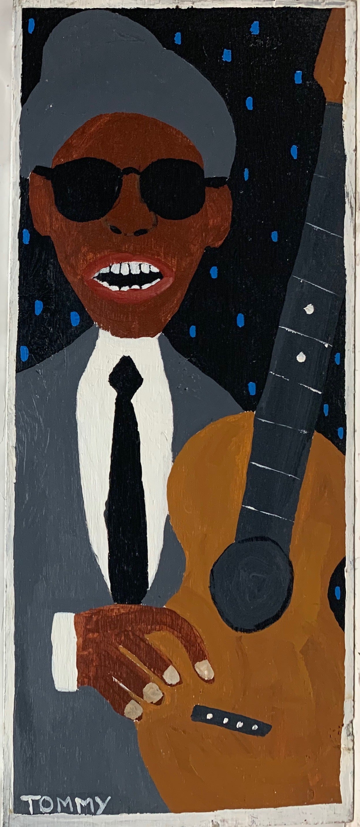 Tommy Cheng portrait of a guitarist in black sunglasses and a gray suit.