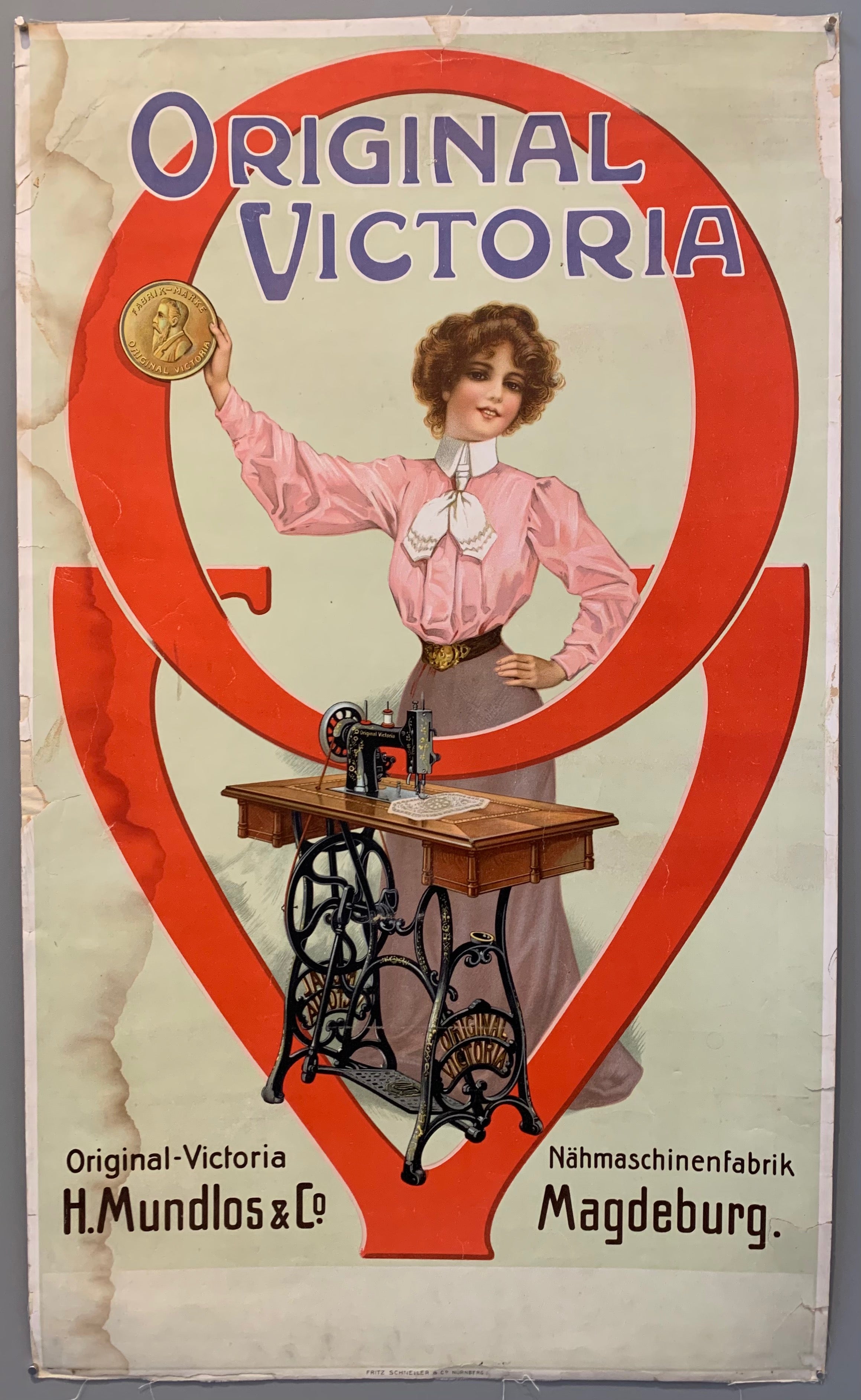 Poster shows a woman in a pink blouse holding up a badge behind a Victoria sewing machine.