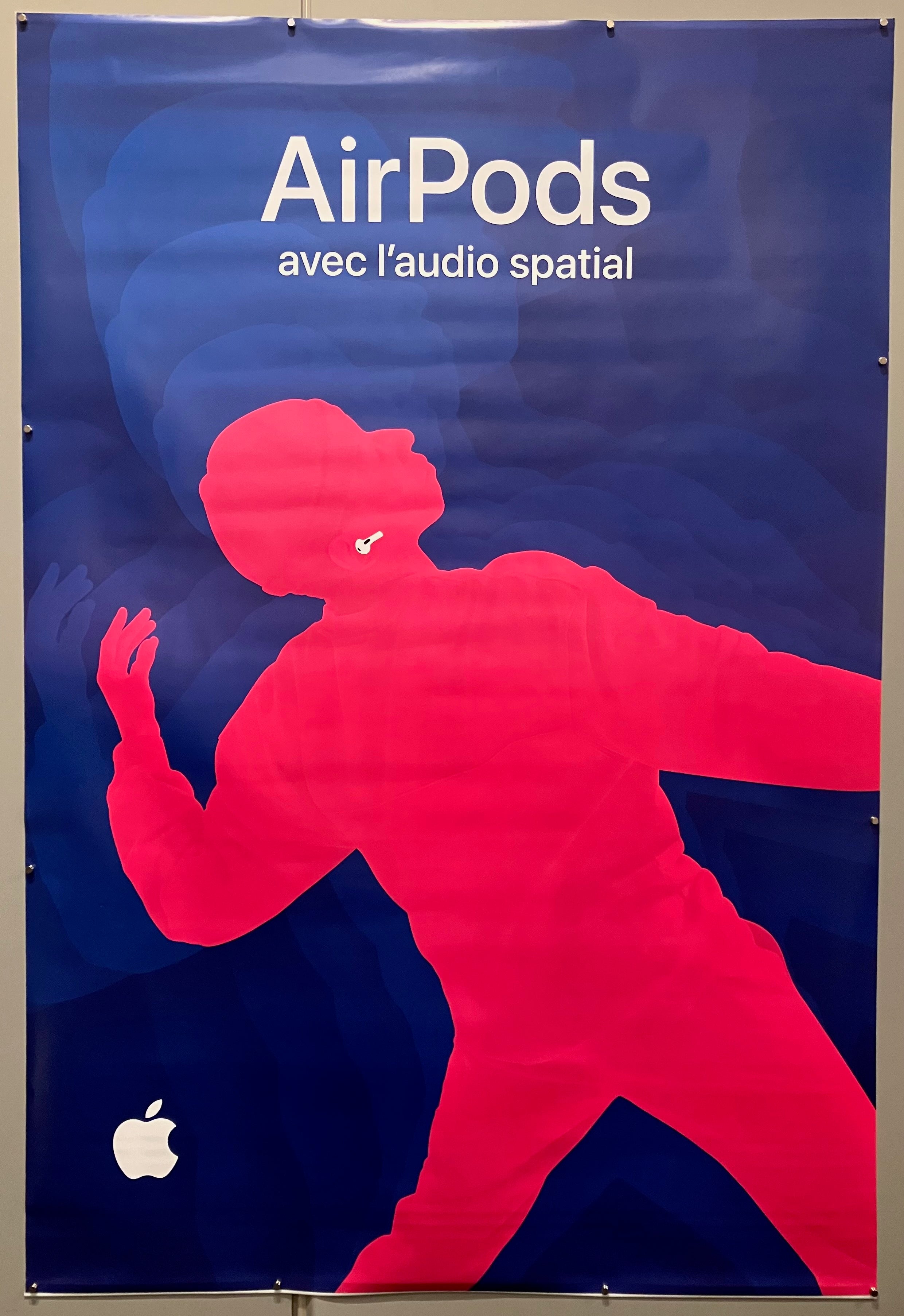 69x47 french apple advertisement for 3rd generation airpods with spatial audio featuring hot pink silhouette of person dancing with white airpods and navy blue background