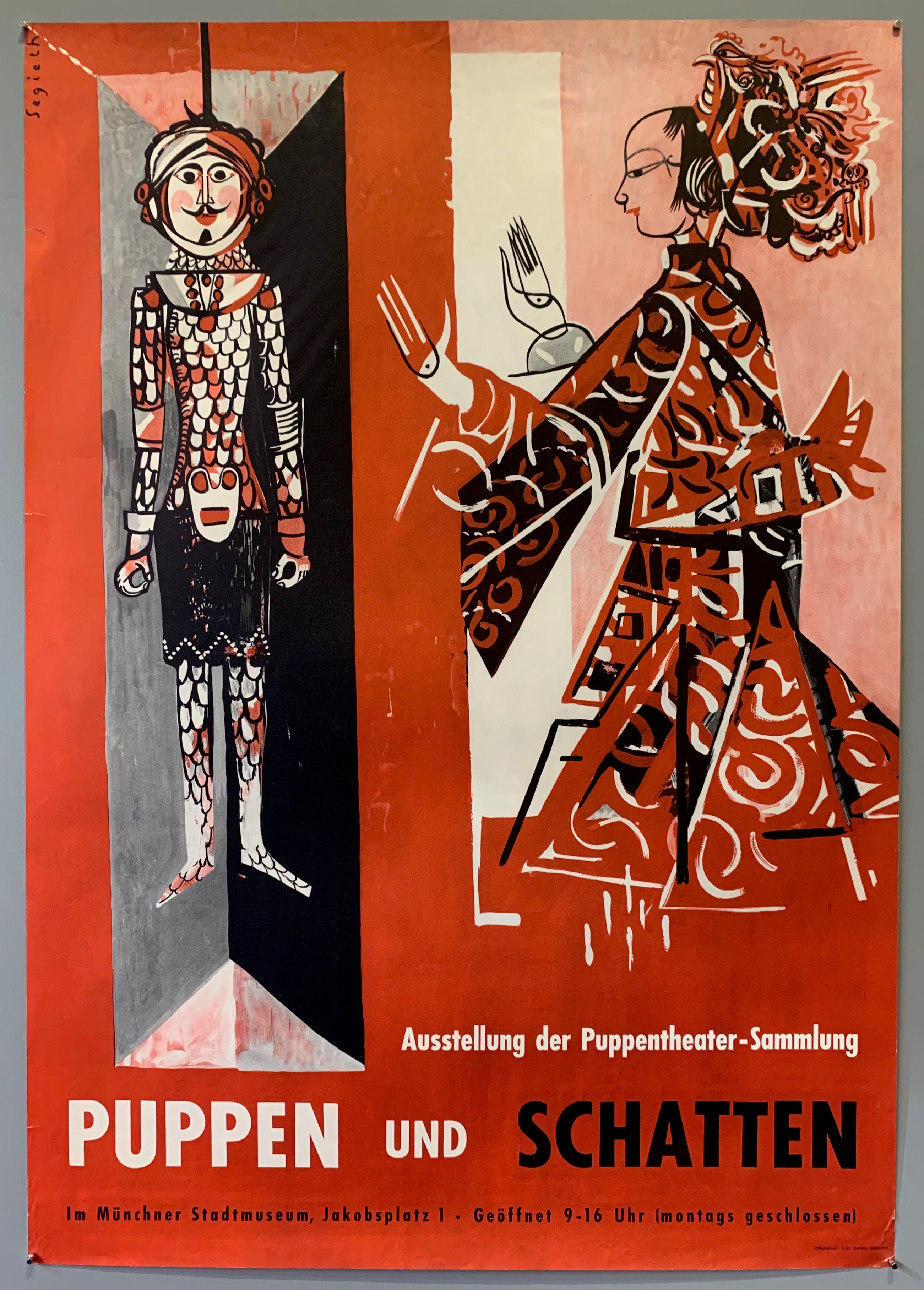 Poster for an exhibit showing at the Muenchner Stadtmuseum in Munich. Exhibit is a puppet exhibit from the puppet theater collection. Poster shows two puppets in red costumes over a red background.