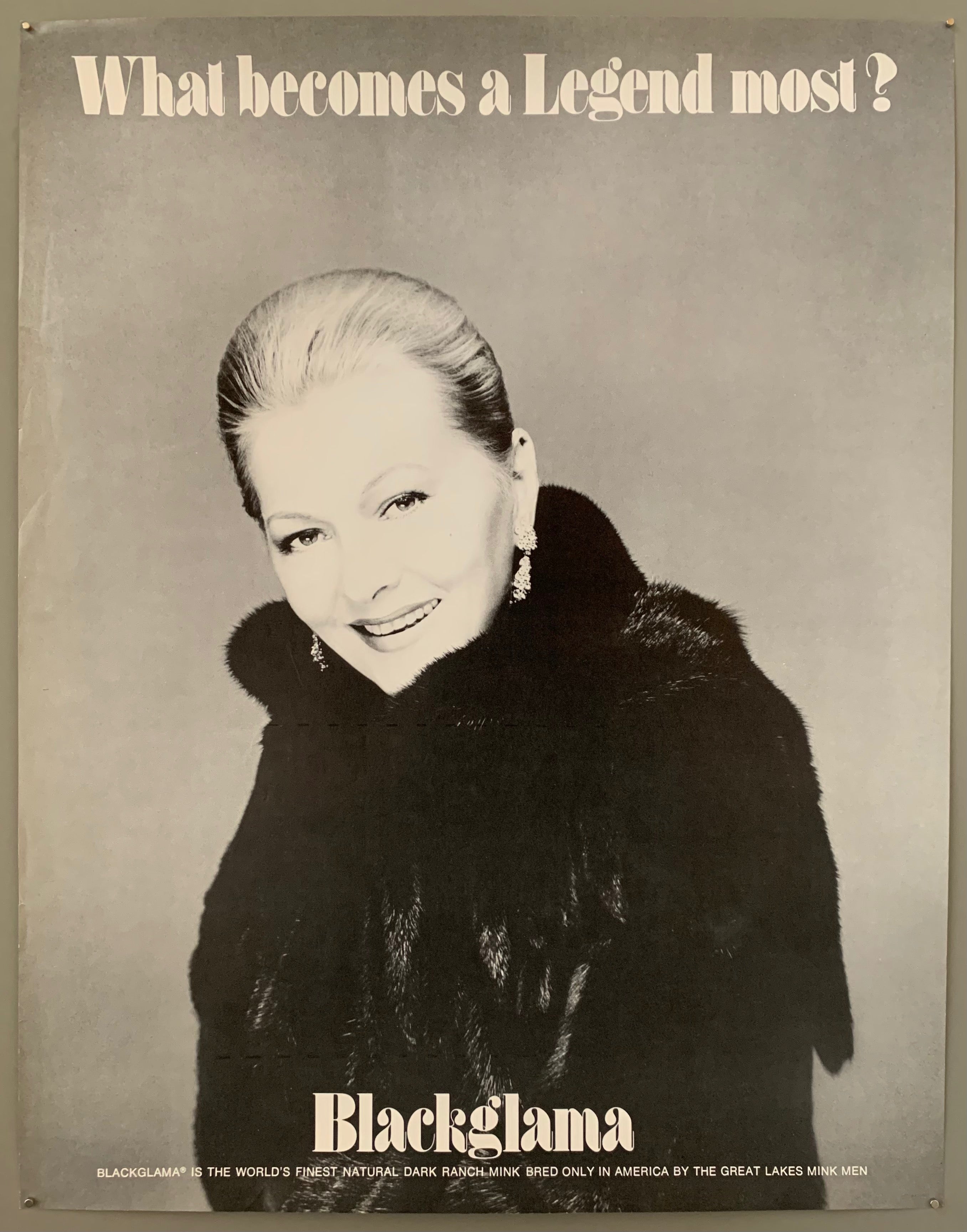 A smiling blonde woman with her hair up in a fur coat. The text is on the top and the bottom in black.