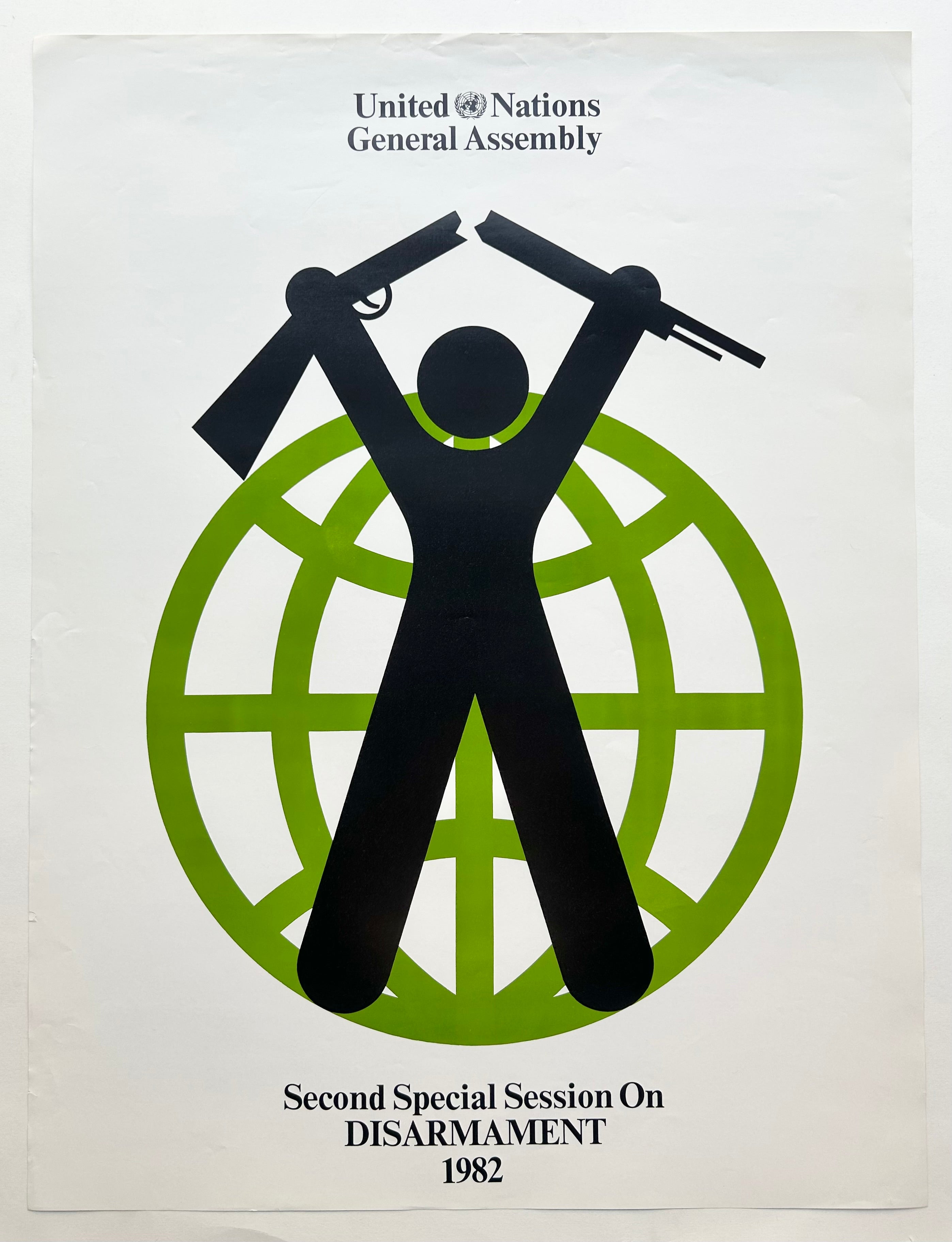 White background with a light green globe outline and an outline of a man in black breaking a rifle laid on top. 